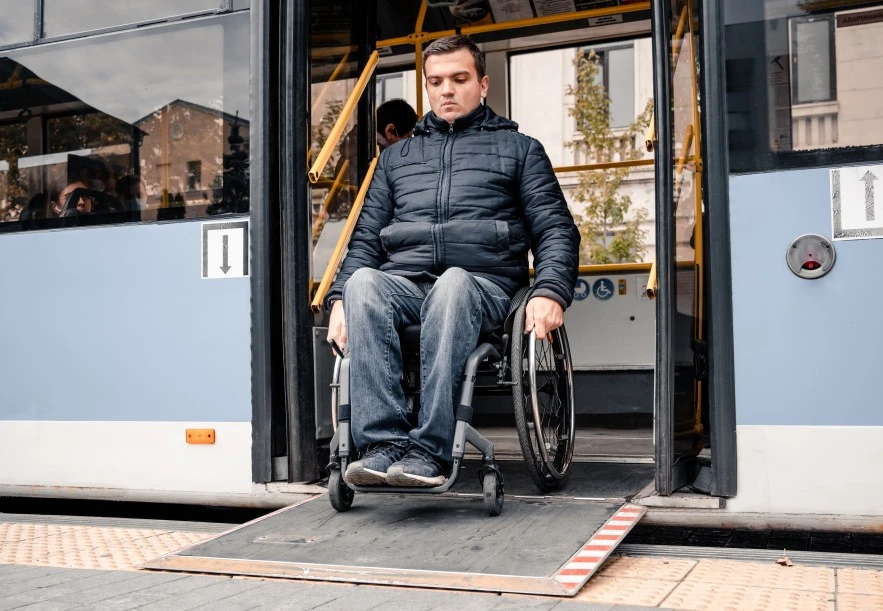 Disabled man in wheelchair getting off bus
