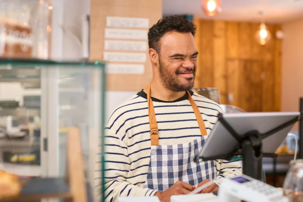 Disabled man with down syndrome working at cafe